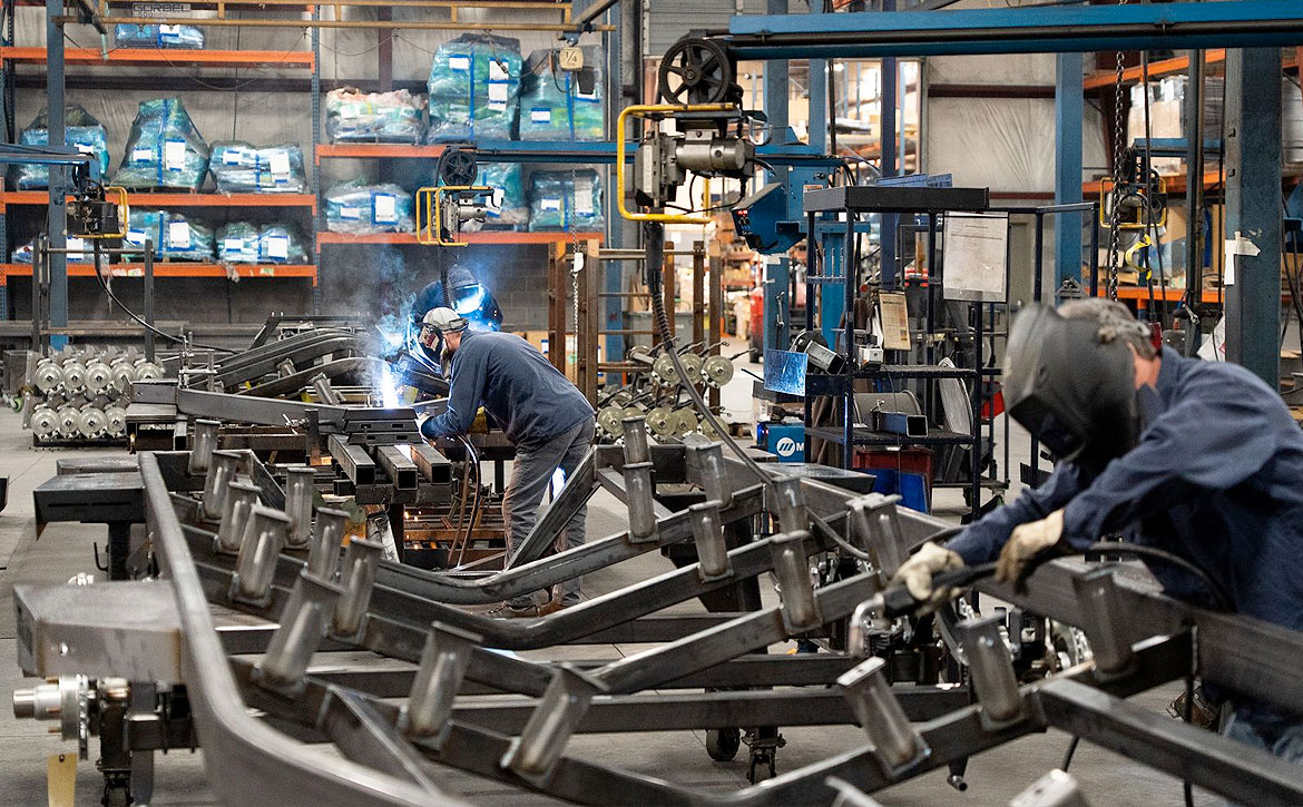 Team of three people working on welding boat trailers at Marine Components.