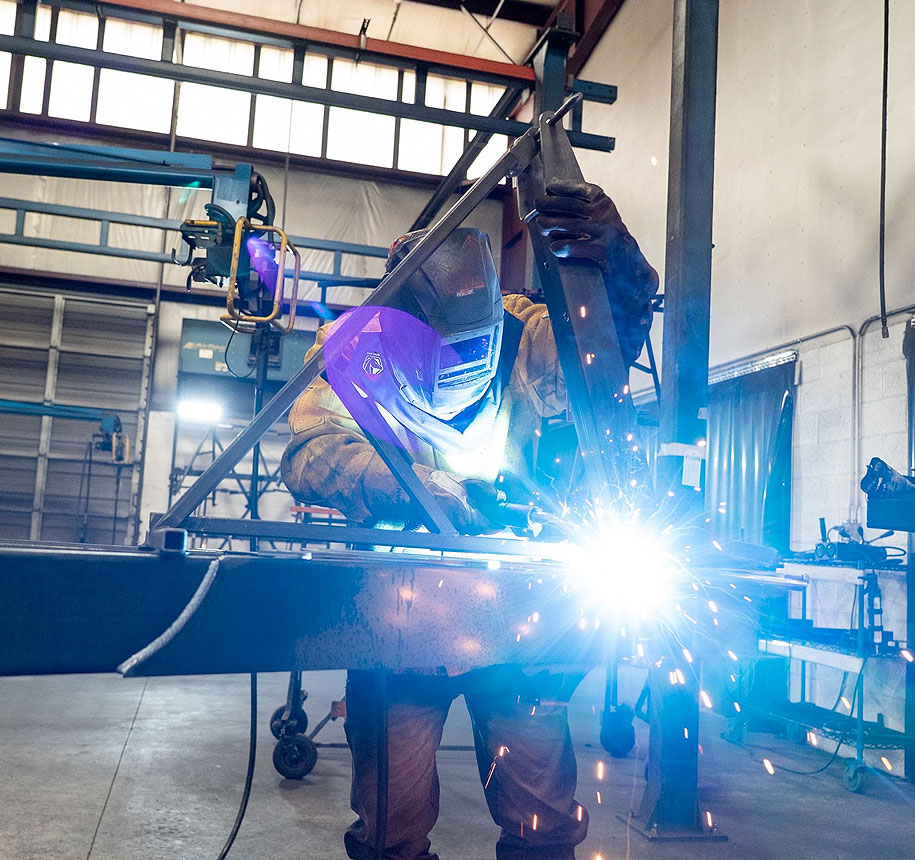 Close up of man welding a boat trailer.