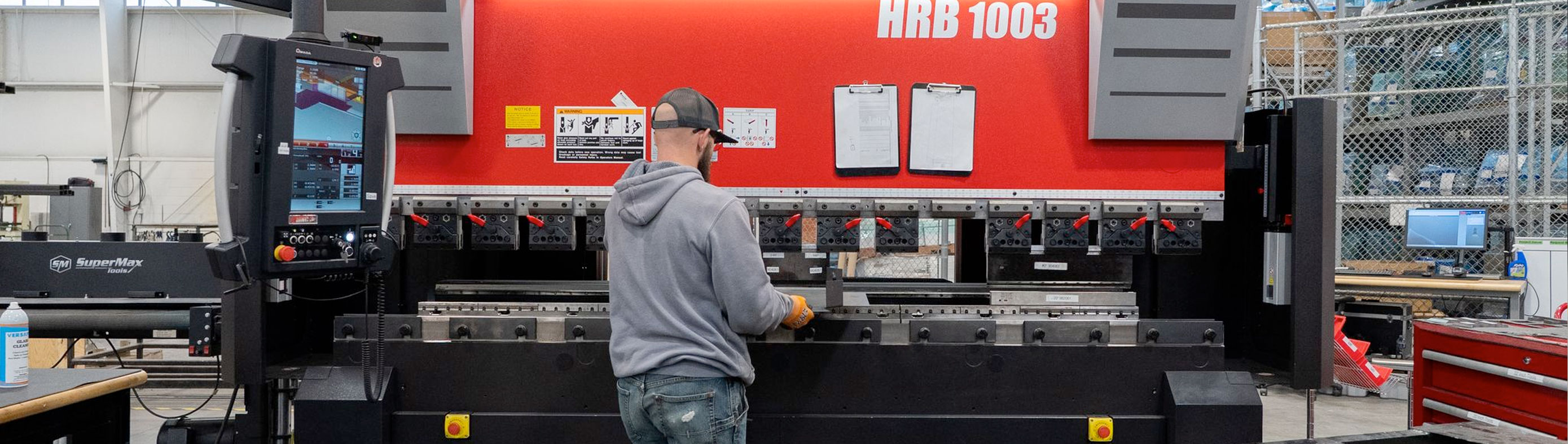Man operating a metal fabrication machine at Marine Components.